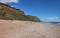 The shingle beach at Eype in Dorset on a sunny day, The sandstone cliffs of the Jurassic coast can be seen in the background