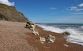 The shingle beach at Eype in Dorset on a sunny day, The sandstone cliffs of the Jurassic coast can be seen in the background