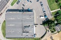 Shingle roof of shopping mall with ventilation systems. parking area with rows of cars. aerial top view