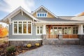 shingle style home with stone accented window wells