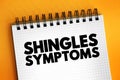 Shingles Symptoms - viral infection that causes a painful rash, medical text concept on notepad