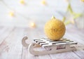 Shining Christmas ball on toy wooden sled on light bokeh background with goolden star. New year card. Xmas decoration