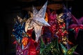 Shining Christmas stars folded from paper in different colors in a market stall, lantern for the dark winter holidays, copy space