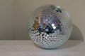 Shining disco ball with a lot of sparkles on table in room as home decor. Cosy home concepr details.