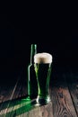 shining glass and bottle of green beer on wooden table, st patricks Royalty Free Stock Photo