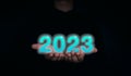 Shining and glow blue 2023 year calendar. The 2023 numbers on the businessman`s hands on dark background. Royalty Free Stock Photo