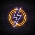 Shining and glowing white lightning neon sign in yellow circle on brick wall