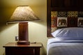 Shining lamp on the table near bed Royalty Free Stock Photo