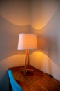 shining lamp on the table near bed.Table lamp dimly shines on the table in the bedroom.Light gleam, shine warm room Royalty Free Stock Photo