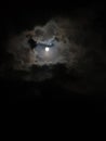 Shining moon in dark sky with clouds
