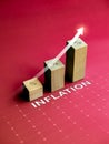 Shining rise up arrow increase on wooden cube blocks, bar graph chart steps with percentage sign and word INFLATION on red. Royalty Free Stock Photo