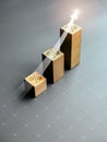 Shining rise up arrow on wooden cube blocks with percentage icon, bar graph chart steps table. Royalty Free Stock Photo