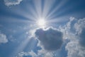 Shining sun half hide by clouds. Beautiful blue sky with sunbeams and clouds. Sun rays over the all image. Royalty Free Stock Photo