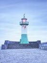 Shinning navigation lighthouse at pier end