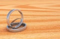 2 Shinny Silver Rings on Lite Wooden base