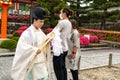 Shinto priest on the way from the temple to a blessing. Fushimi Inari-Taish Shrine, Kyoto, Japan