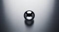 A shiny black sphere rests on a polished metallic surface. The sphere displays a reflective Royalty Free Stock Photo