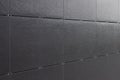 Shiny black surface of building wall with bracketed tiles Royalty Free Stock Photo