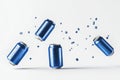 Shiny blue aluminum cans falling and bouncing on a white surface, ice cubes flying everywhere Royalty Free Stock Photo