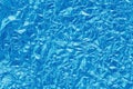 Shiny blue foil texture background, pattern of cyan wrapping paper with crumpled and wavy Royalty Free Stock Photo