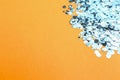 Shiny bright light blue glitter on pale orange background, closeup. Space for text Royalty Free Stock Photo