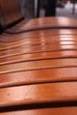Shiny brown wooden bench perspective on blurred city street background Royalty Free Stock Photo