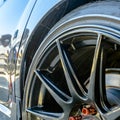 Shiny car with black mag wheel and red lug nuts Royalty Free Stock Photo