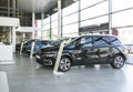 Shiny cars standing in a row in bright elegant car rental interior with windows on wall