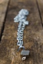 shiny chain with padlock unlocked on a wooden table Royalty Free Stock Photo