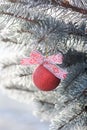 Shiny Christmas ball with a ribbon on a snow-covered tree. Christmas background. Royalty Free Stock Photo