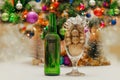 shiny christmas balls in a beer glass next to a green bottle and a decorated new year tree Royalty Free Stock Photo