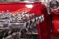 Shiny chrome exhaust on red hot rod engine
