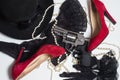 Shiny chrome revolver, black women`s hat, stockings, gloves, red shoes and pearl beads on a white Royalty Free Stock Photo