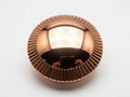 Shiny copper colored round metal object with grooved edges isolated on white background Royalty Free Stock Photo