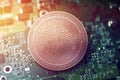 Shiny copper ICOS cryptocurrency coin on blurry motherboard background