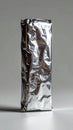 Shiny Crinkled Foil Wrapped Package on a White Surface Royalty Free Stock Photo