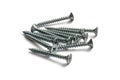 Shiny galvanized self-tapping screws on white background