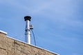 Shiny galvanized ventilation pipe on the roof of the building.