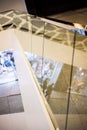 Shiny glass railing, modern elegant staircase between the floors of the shopping center, the reflection of the ceiling lighting