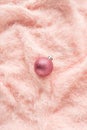 Shiny glittering Christmas ball on pink fluffy fur background. Copy space, flat lay. Minimal Christmas or New Year holiday concept Royalty Free Stock Photo