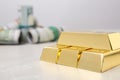 Shiny gold bars and dollar rolls on table, closeup Royalty Free Stock Photo