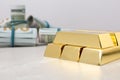 Shiny gold bars and dollar rolls on table Royalty Free Stock Photo