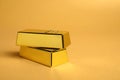 Shiny gold bars on pale orange background, closeup. Space for text Royalty Free Stock Photo