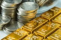 shiny gold bars with stack of coins as business or financial investment and wealth concept