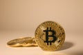 Shiny gold bitcoins on beige background