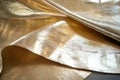Shiny gold leaf texture, delicate overlapping sheets with rich metallic tones and subtle