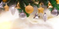 Shiny gold and silver christmas balls, stars and bells on white with pine tree for new year
