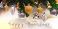 Shiny gold and silver christmas balls, stars and bells on white with pine tree for new year with happy new year text Royalty Free Stock Photo