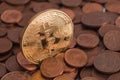 Shiny golden Bitcoin sticking out from pile of old euro cent coins