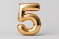 Shiny golden number five with reflective metallic surface standing alone on plain light background symbolizing luxury and Royalty Free Stock Photo